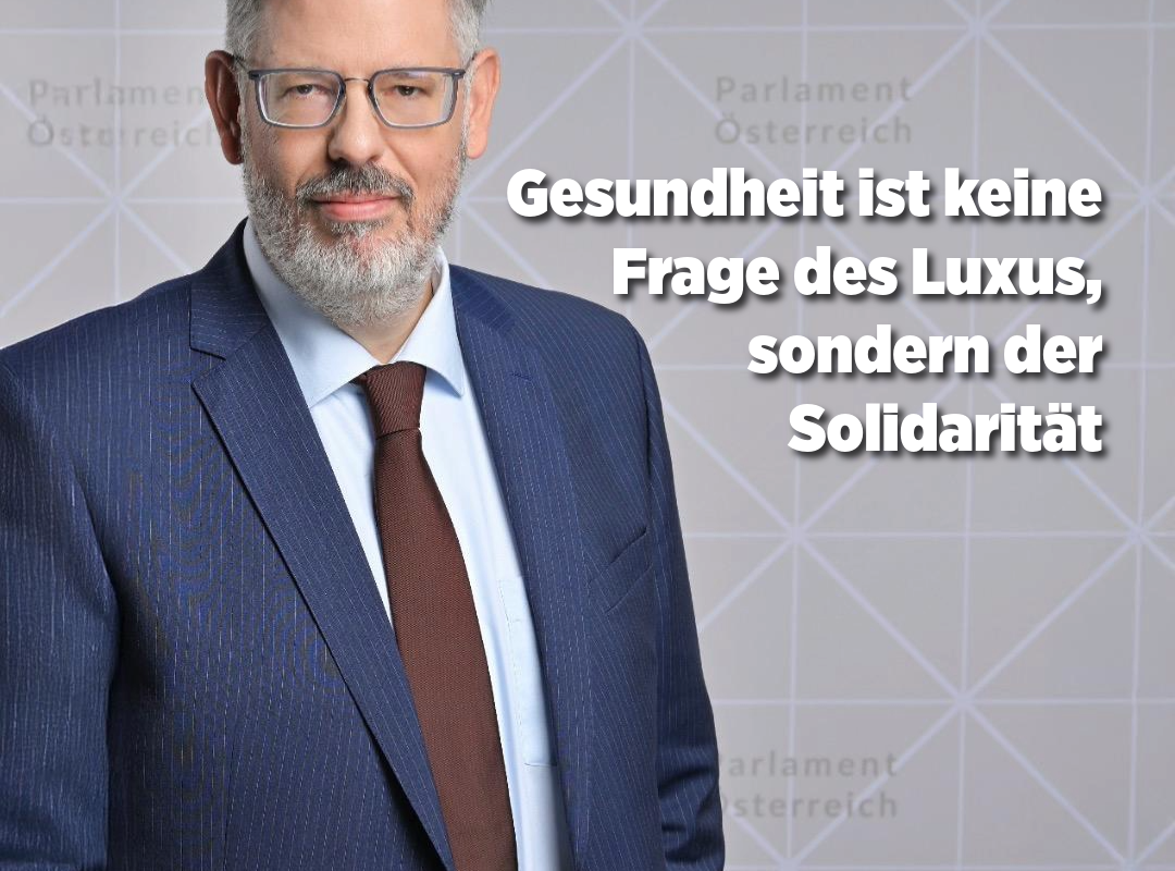 Ein Mann im Anzug mit grauen Haaren und Bart steht vor einem Hintergrund mit einem geometrischen Muster und dem Schriftzug 'Parlament Österreich'. Es handelt sich hier um den Abgeordneten Ralph Schallmeiner. Neben ihm steht der Text: "Gesundheit ist keine Frage des Luxus, sondern der Solidarität"